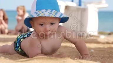 小男孩<strong>在海滩上</strong>潮湿的沙滩<strong>上玩耍</strong>。 他学会爬行，波浪拥抱他。